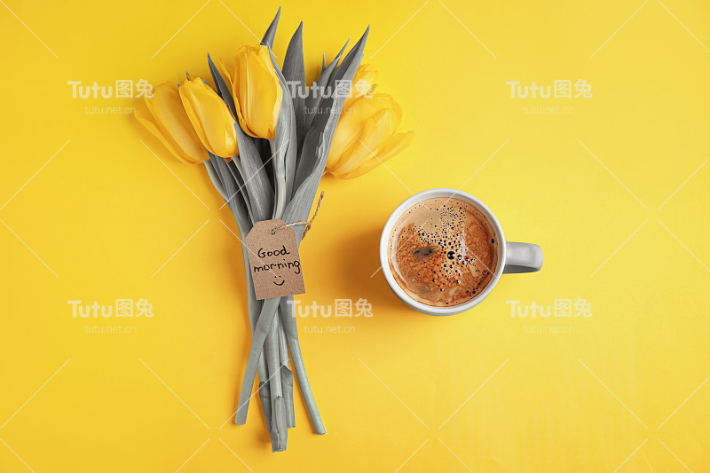 2021年的颜色。芳香的咖啡，美丽的郁金香和早安祝愿在黄色的背景，平铺