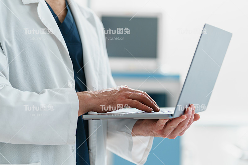 现代诊所手术室中医生用手提电脑的手特写