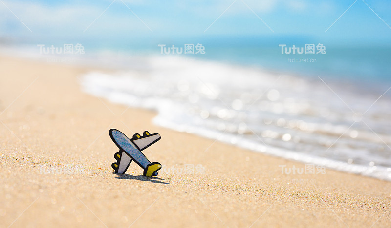 以海浪为背景的沙滩上的小飞机雕像。