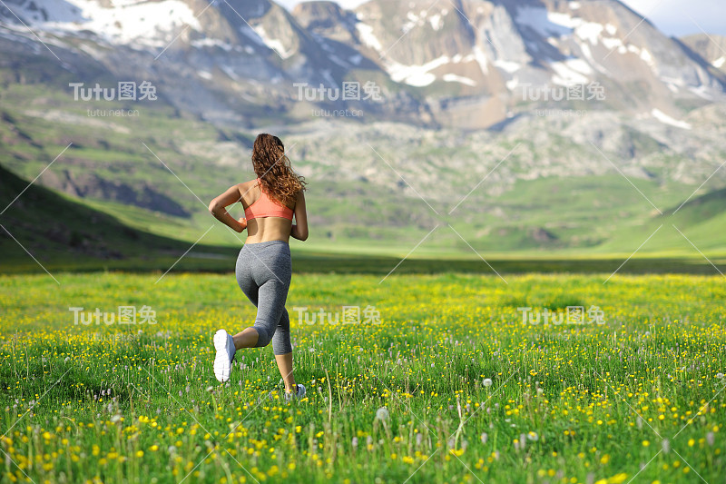 一个跑步的女人在山上跑步的背影