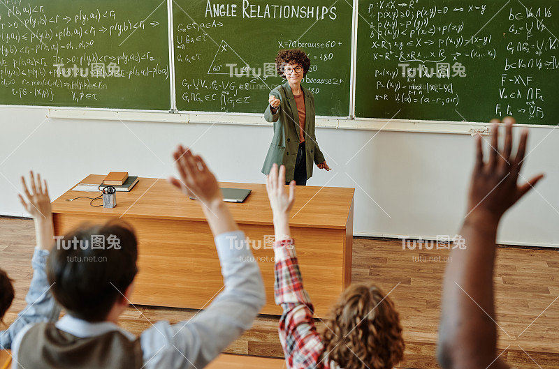 成功的老师指着一名跨种族学生举起的手