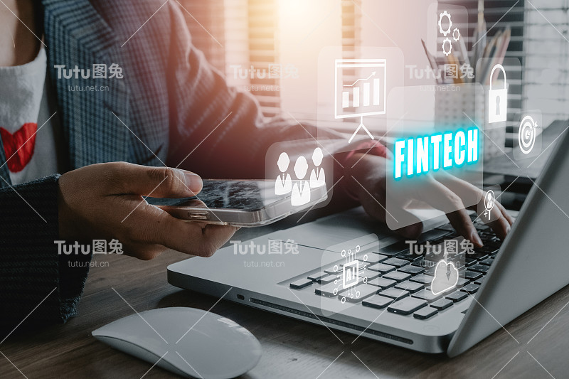 Fintech金融技术加密货币投资和数字货币，商务人士使用办公桌上的笔记本电脑，VR屏幕上有Fintech图标。