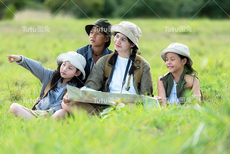 成群的家庭孩子在丛林探险中查看地图。亚洲人旅游的目的地休闲旅行，教育和放松的自然公园。旅行假期和生活理念