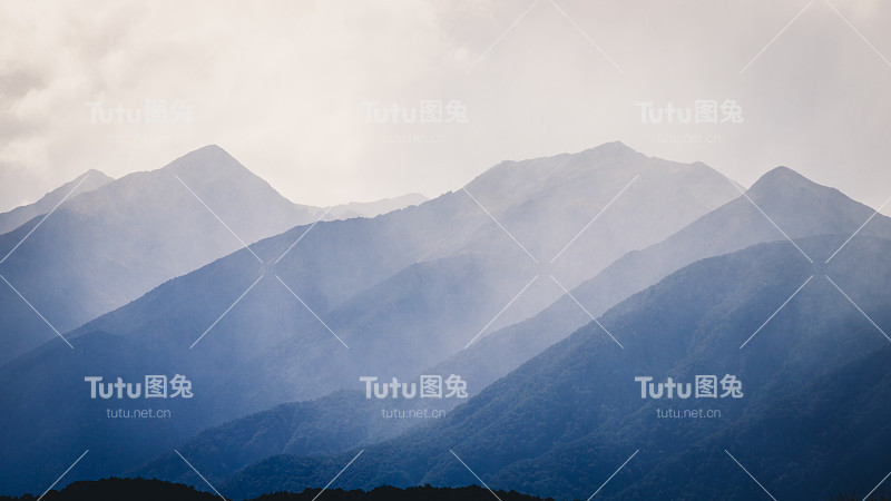 景区景色湛蓝雾蒙蒙，林木茂密，山峦朦胧