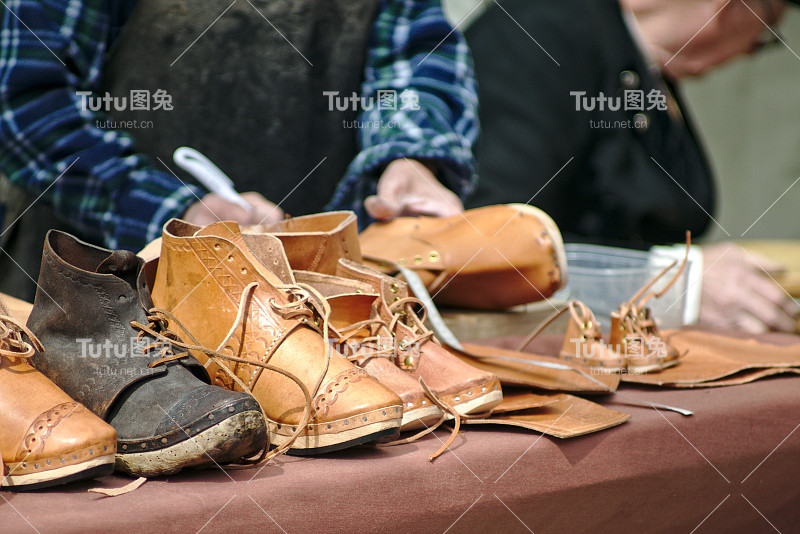一个鞋匠在桌子上为靴子草图设计的特写
