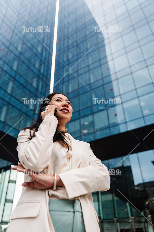 年轻的亚洲职业女性在公司办公城市打电话-商业灵感