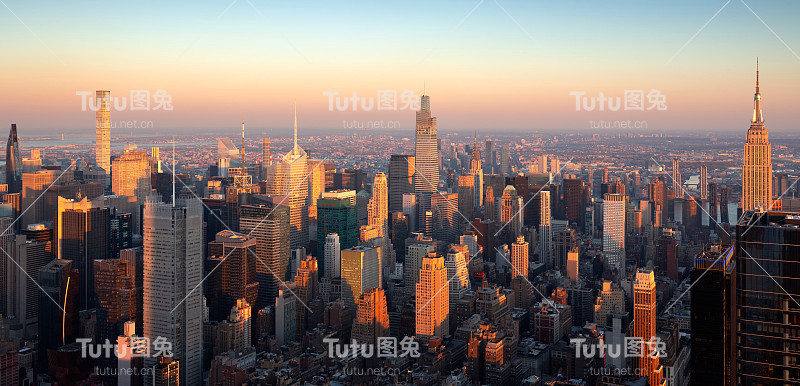 在夕阳的温暖光线下，俯瞰曼哈顿中城摩天大楼的全景