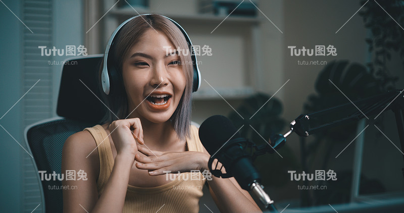 开朗的年轻播客使用麦克风在演播室的在线播客