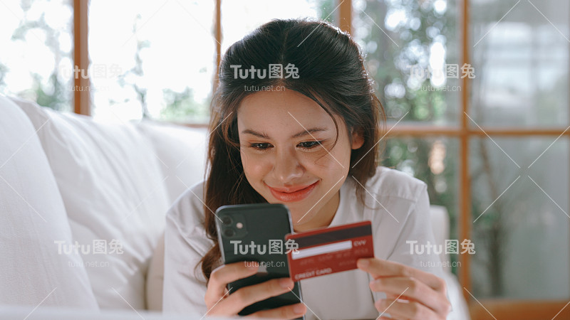 女性在网上购物或支付网上市场浏览出售物品的现代生活方式，并使用信用卡在线支付钱包由活跃的网络安全软件保护