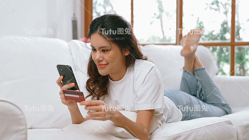 女性在网上购物或支付网上市场浏览出售物品的现代生活方式，并使用信用卡在线支付钱包由活跃的网络安全软件保护