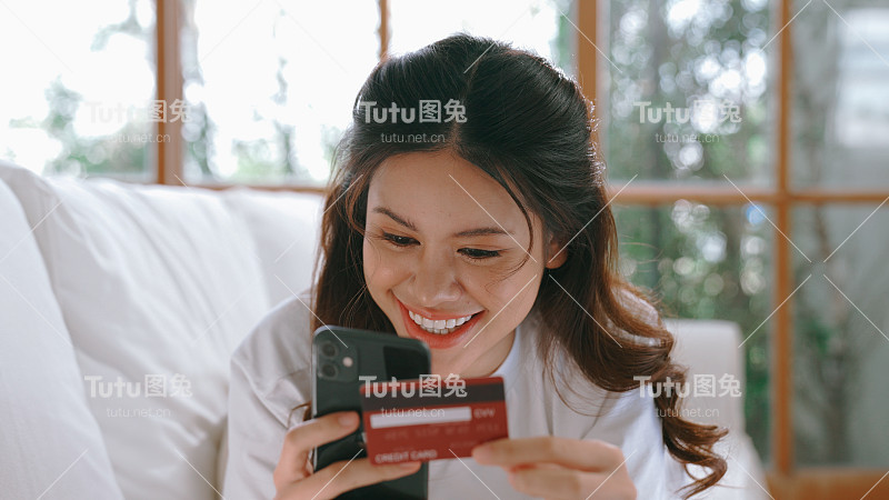 女性在网上购物或支付网上市场浏览出售物品的现代生活方式，并使用信用卡在线支付钱包由活跃的网络安全软件保护
