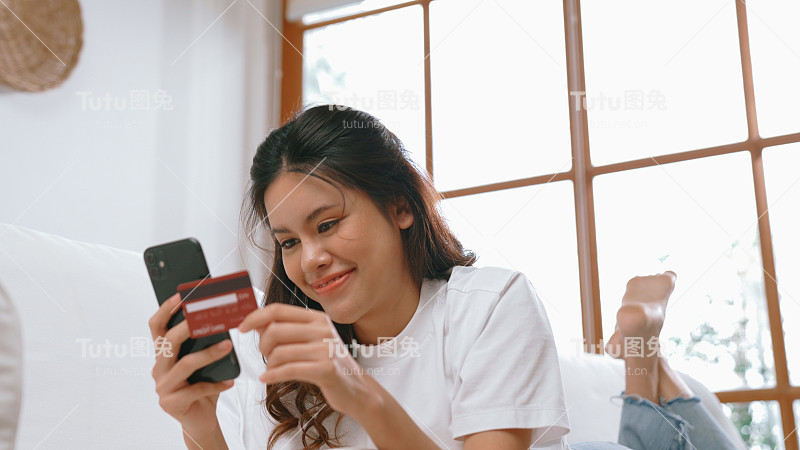 女性在网上购物或支付网上市场浏览出售物品的现代生活方式，并使用信用卡在线支付钱包由活跃的网络安全软件保护