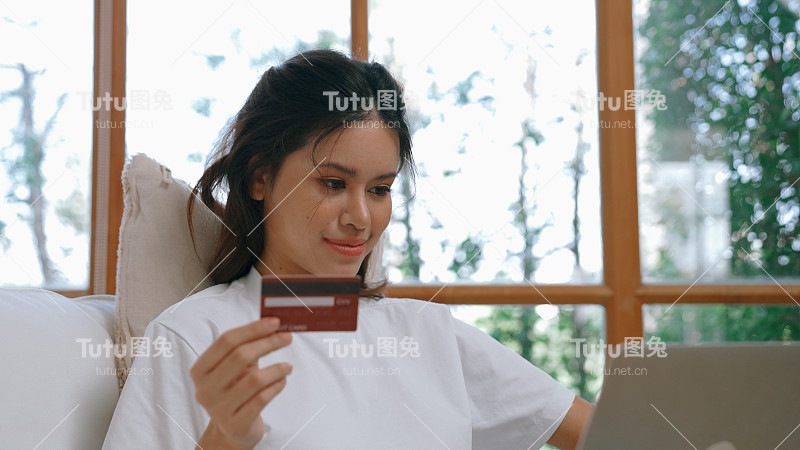 女性在网上购物或支付网上市场浏览出售物品的现代生活方式，并使用信用卡在线支付钱包由活跃的网络安全软件保护