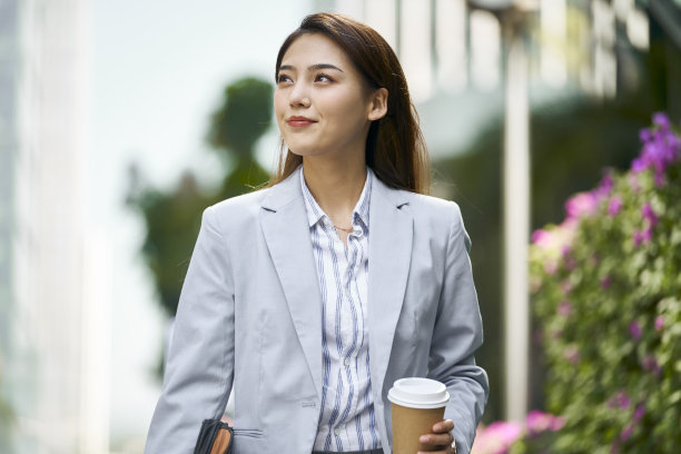 成功的年轻亚洲商业女性办公室职员走在大街上