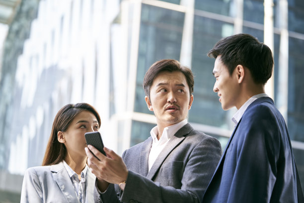 由三名亚洲公司高管组成的团队站在街上讨论业务