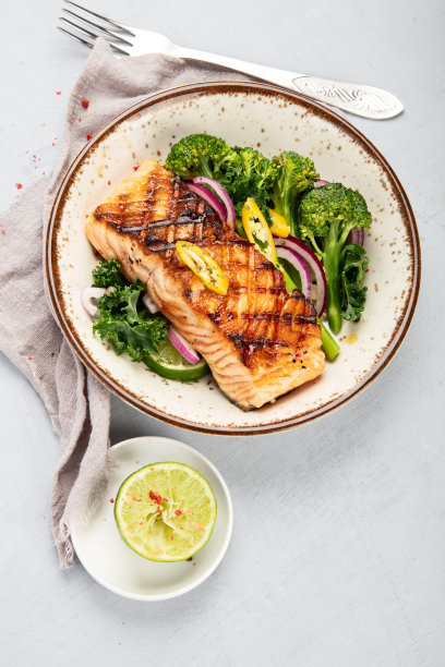 浅背景烤三文鱼配蔬菜。