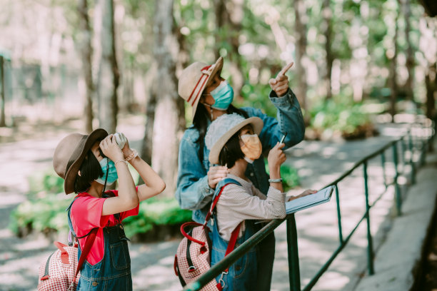 父亲和孩子们在蓝天下的草地上玩耍