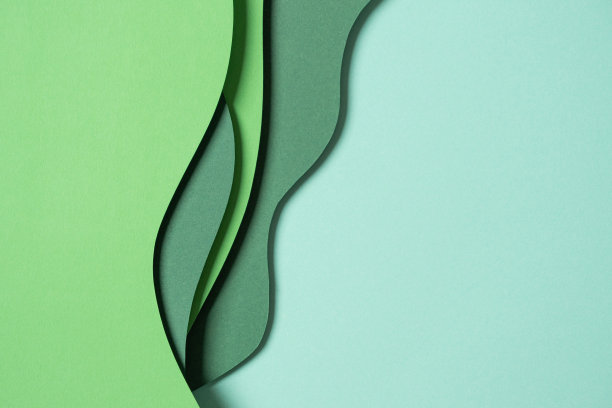 抽象的绿色彩色纸纹理背景。最小的剪纸风格组成的几何形状和绿色色调阴影线层。俯视图